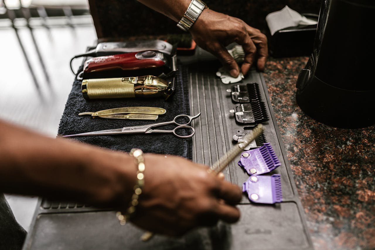 High-angle shot of barber tools on a work mat, including scissors and clippers.
